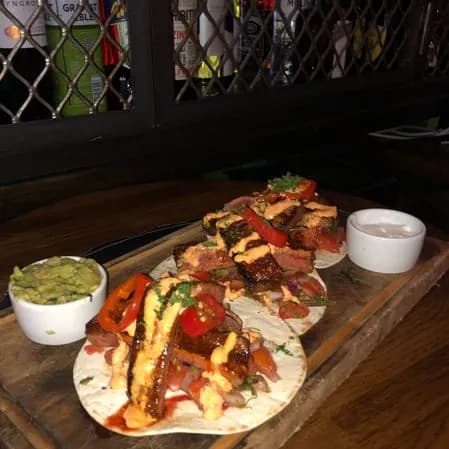 Amerikanska tacos med guacamole på en träbricka